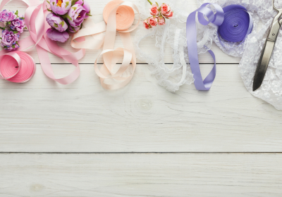 Colorful ribbons and garter on wooden table, wedding preparations background
